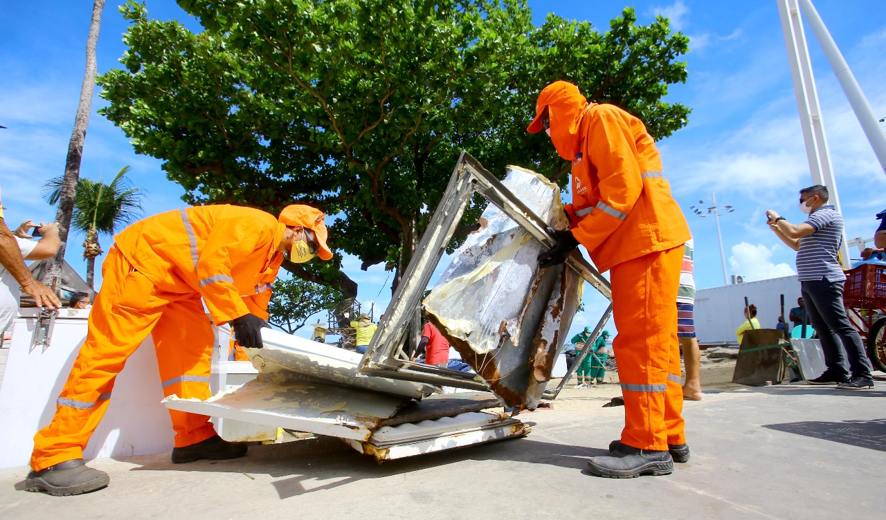 operário retiram entulho na beira-mar